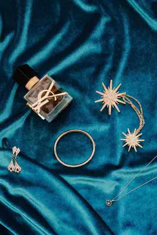 Bridal accessories flatlay with perfume and jewelry by Estudio Zoe