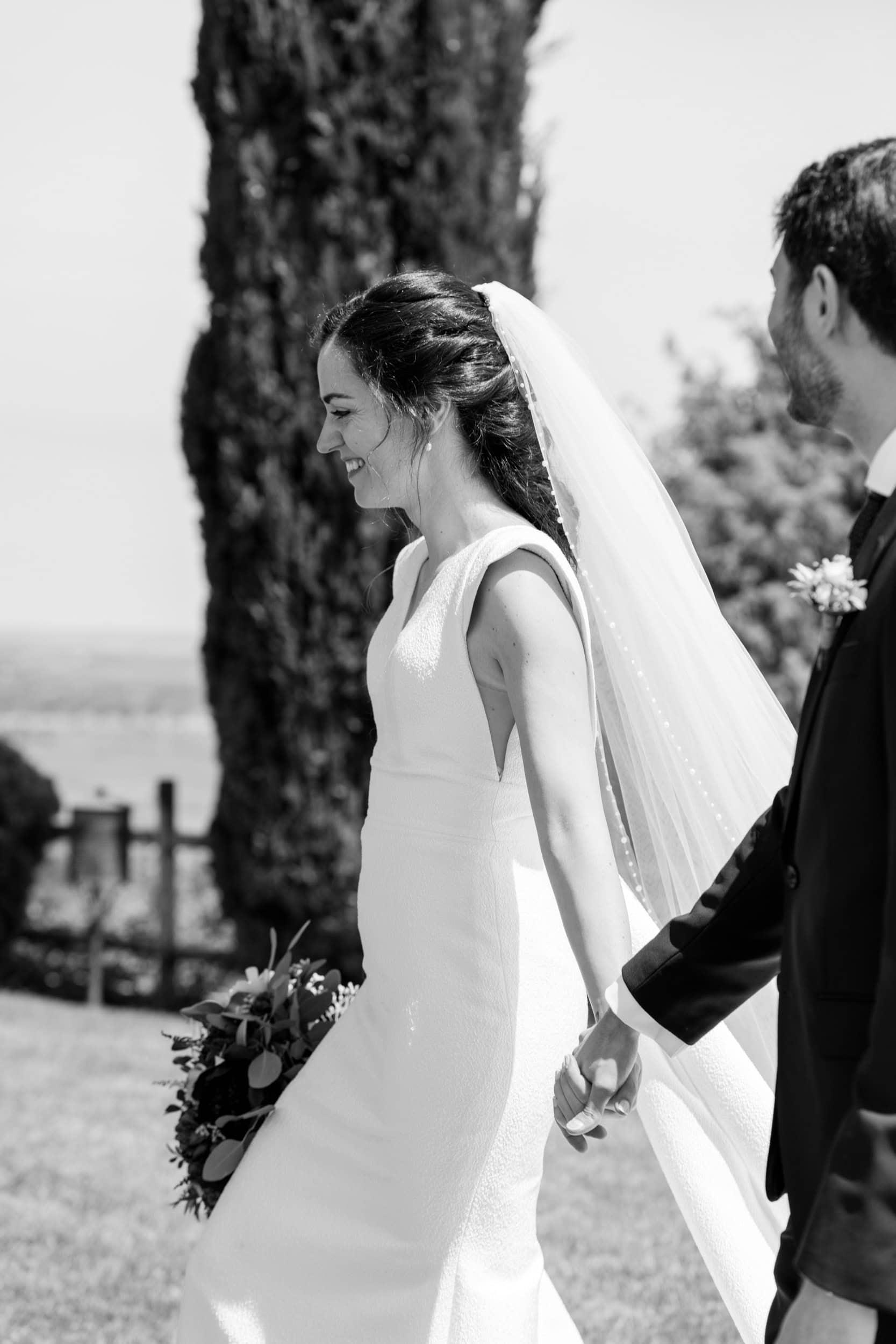 Black and white candid bride walking and laughing by Estudio Zoe