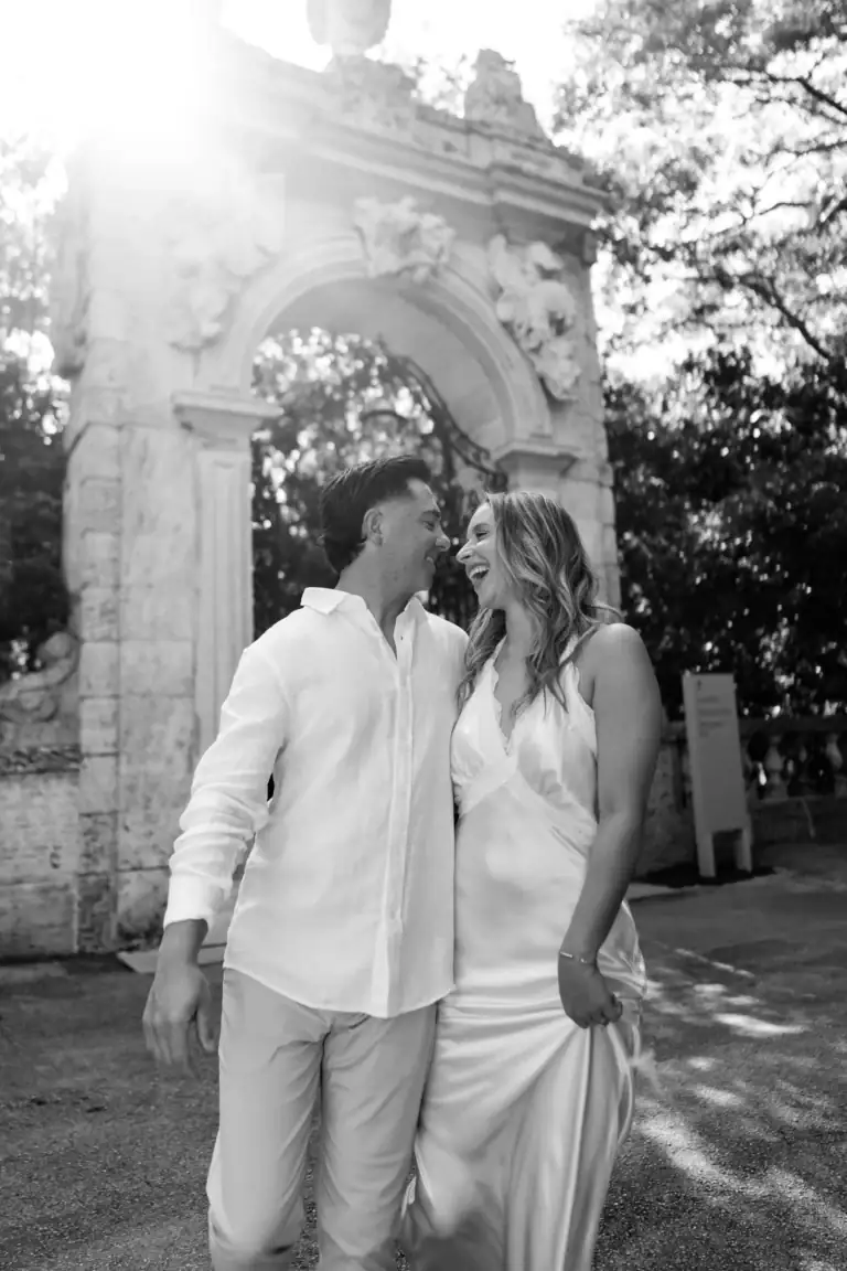 Black and white photo of Gabby and Mike walking during their Vizcaya Gardens engagement session in Miami