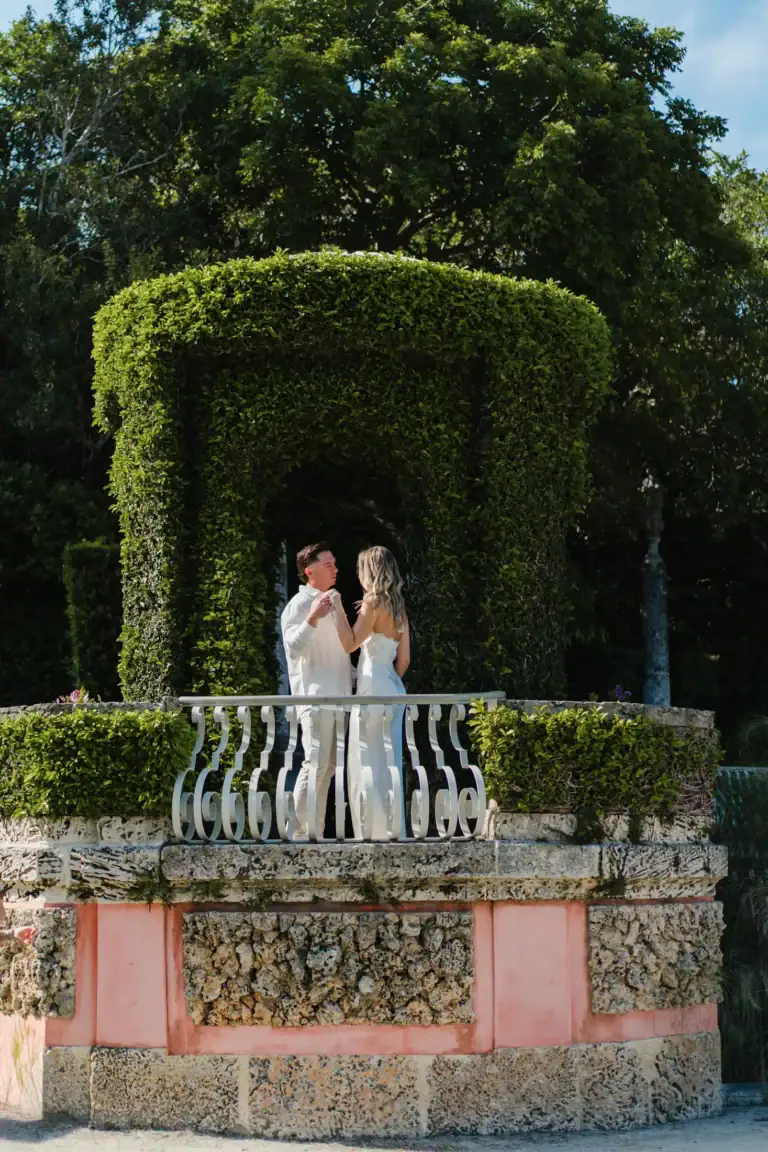 Gabby beside a green garden arch at Vizcaya