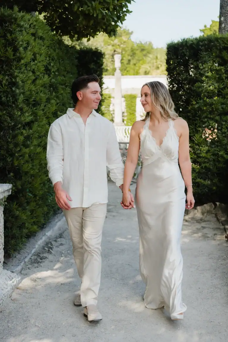 Gabby and Mike walking together along a garden path at Vizcaya