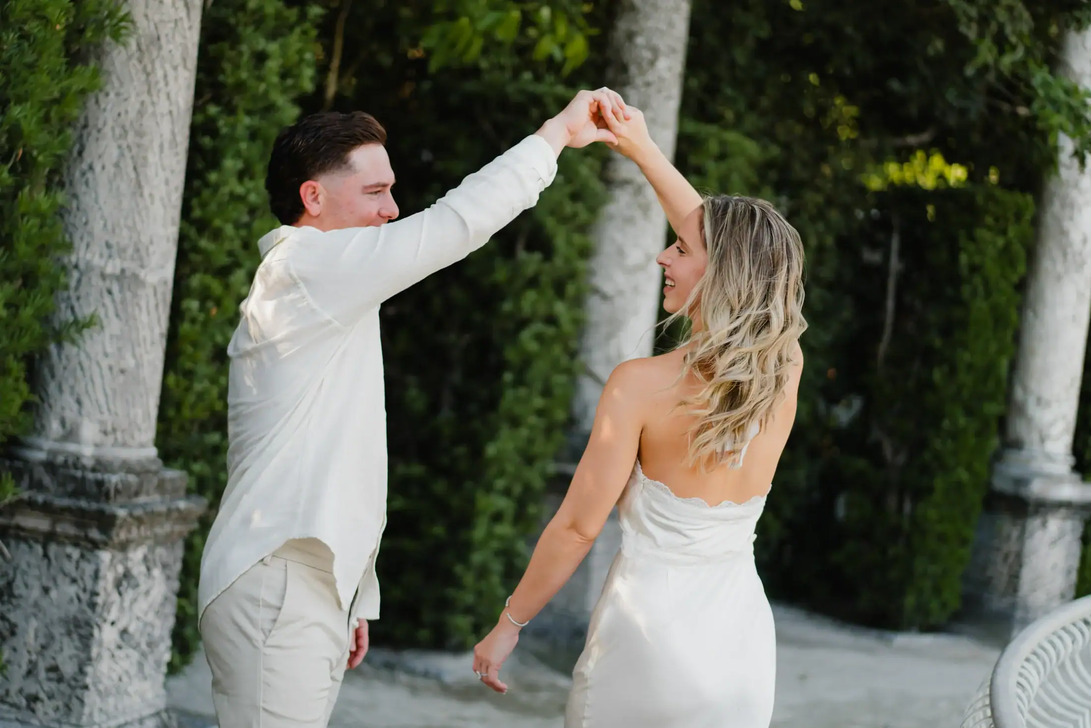 Gabby and Mike holding hands in the gardens at Vizcaya Museum and Gardens
