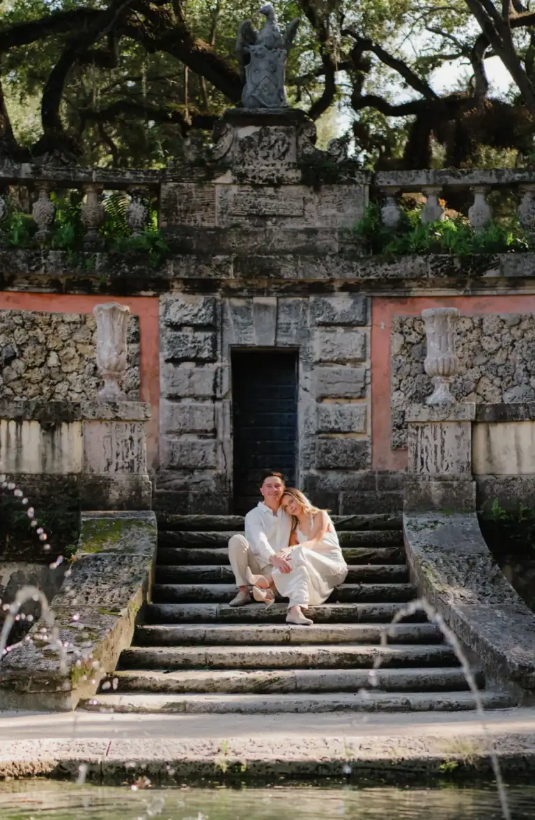 Gabby and Mike sitting together on stone steps at Vizcaya