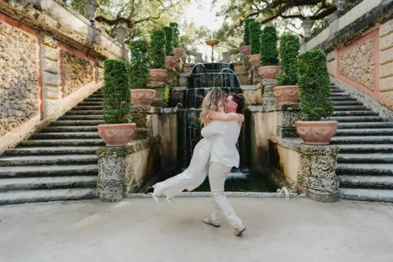 Gabby and Mike seated together on stone steps at Vizcaya