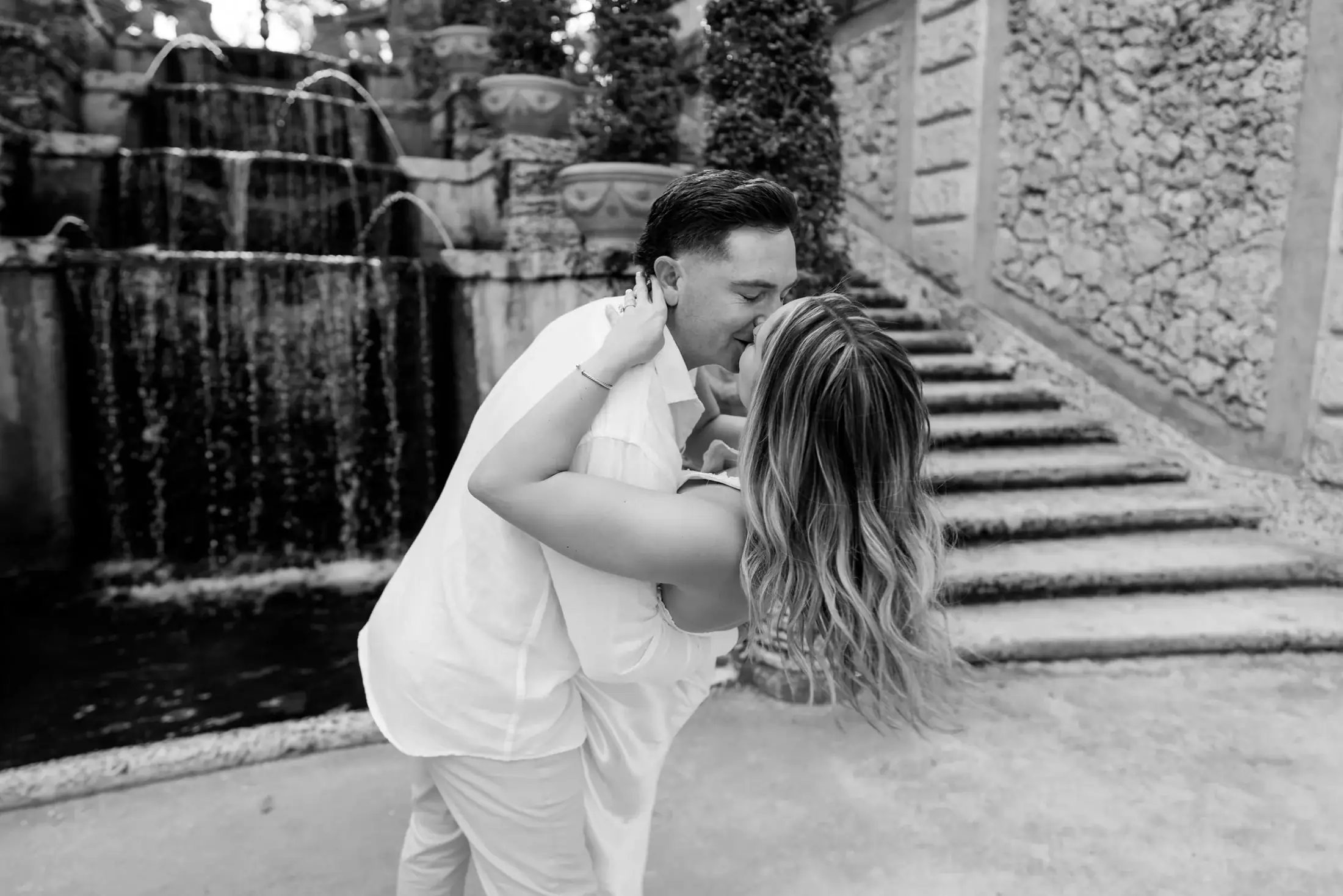 Black and white seated portrait of Gabby and Mike during their Vizcaya engagement session