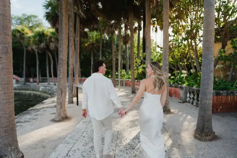 Gabby and Mike walking beside the water during their engagement photos at Vizcaya Miami